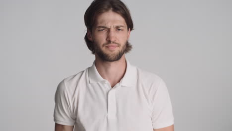 caucasian man in front of camera on gray background.