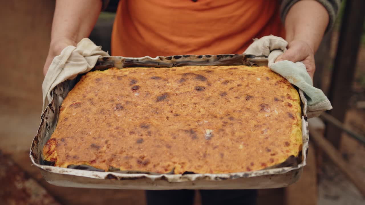 Kvinde viser kameraet den paraguayanske suppe, klar til at spise.
