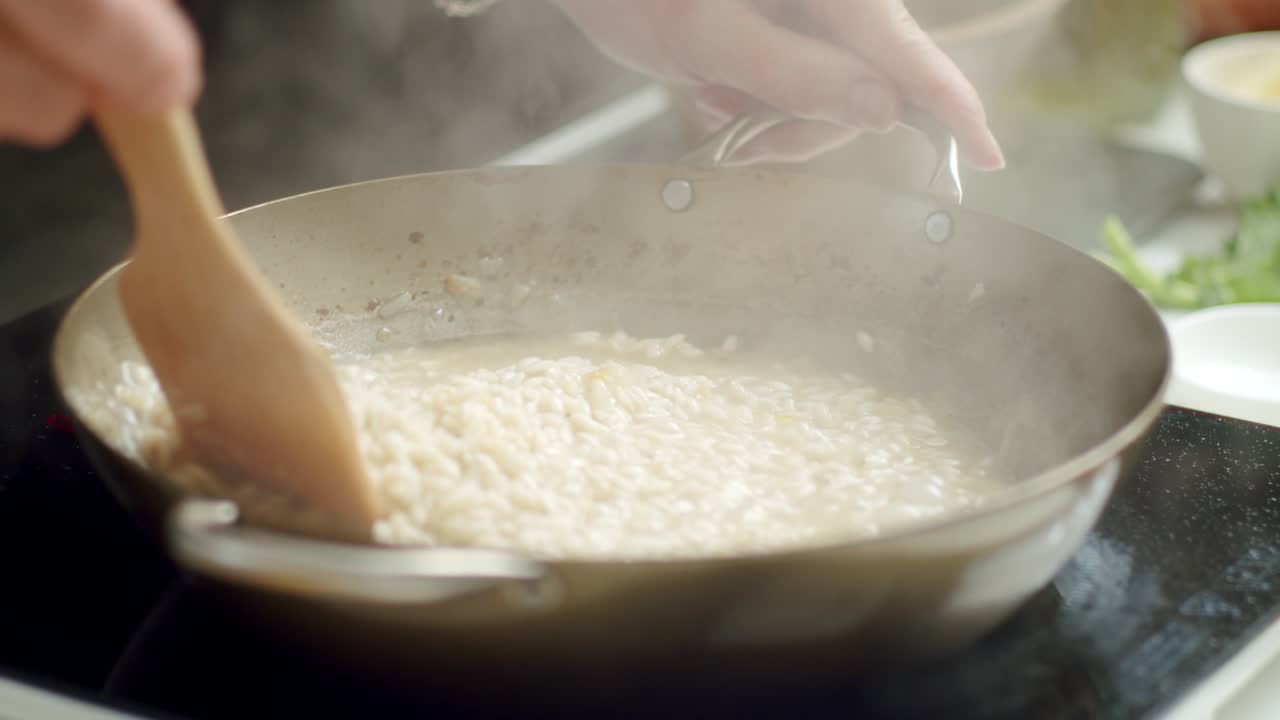 cocinero irreconocible preparando risotto en una sartén