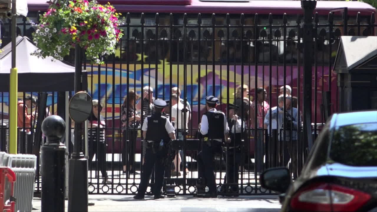 Urban Street Scene with Security, People, and a Double-Decker Bus
