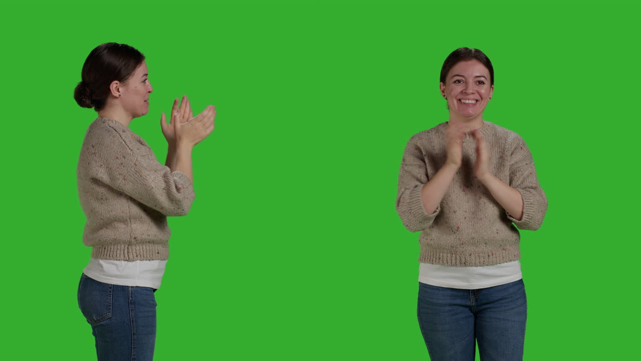 Woman clapping against green screen