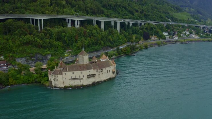 CHILLON CASTLE Switzerland city is coming back and there are many trees around the castle, and weaves in the water