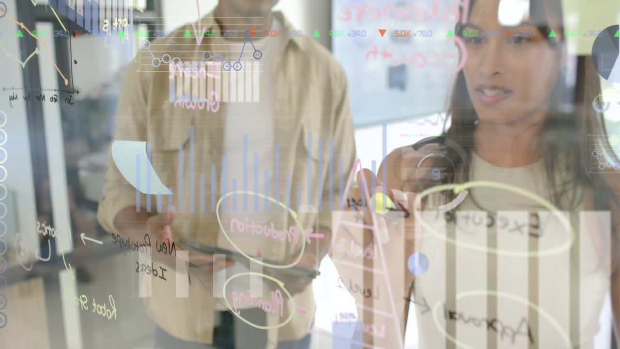 Woman picking marker and marking glass charts while peer using tablet, overlays highlighting plan