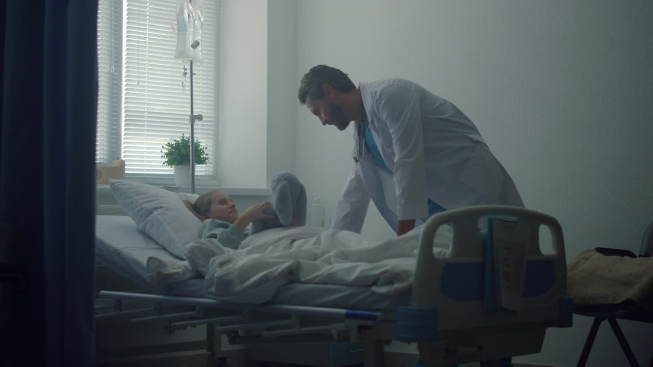 un médico amigable hablando con un pequeño paciente en la sala de operaciones. interior moderno.