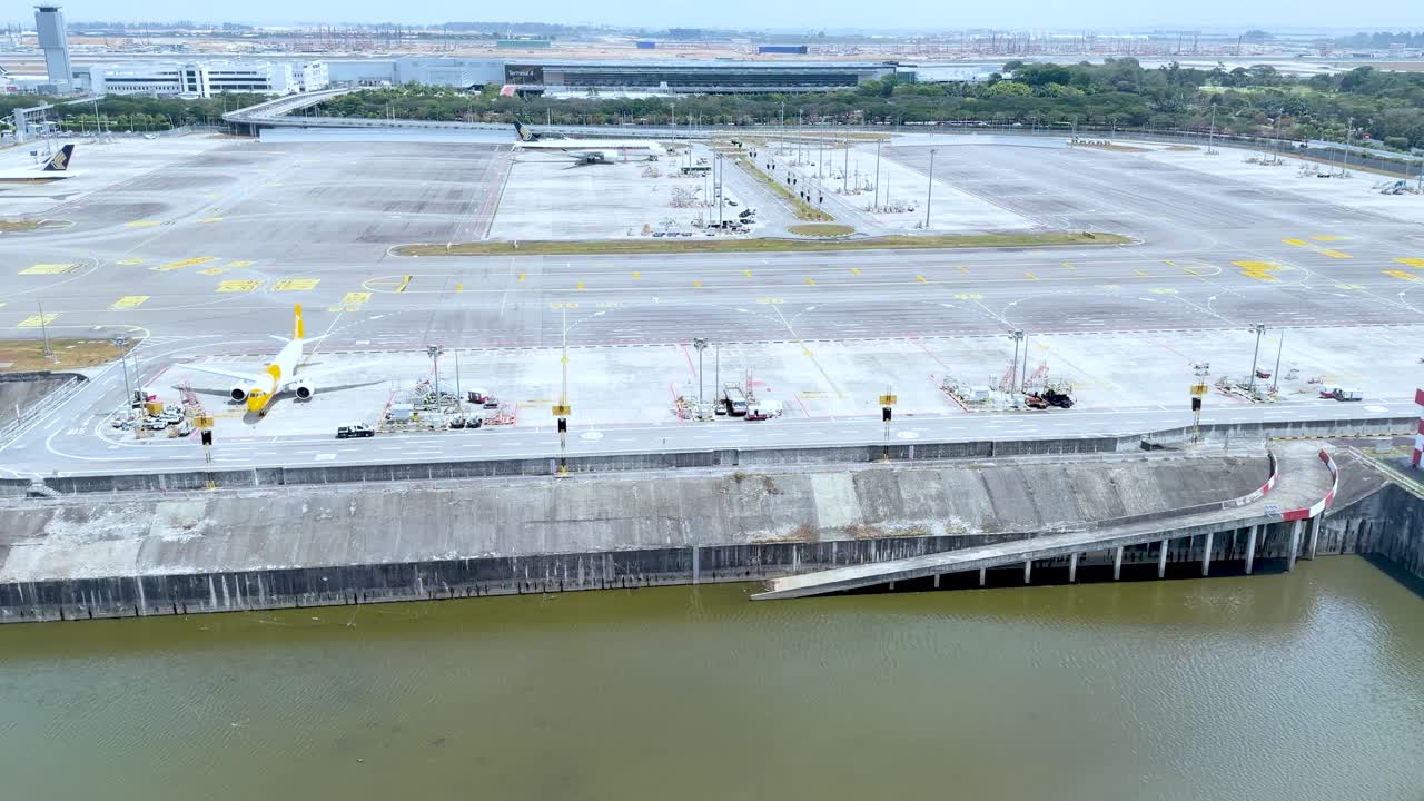Toma aérea de picado de la plataforma y pista de un aeropuerto junto al agua en Phuket.