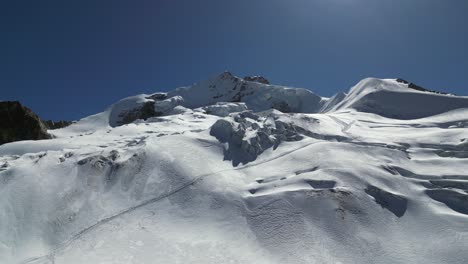 mountain peak beauty: climber tracks across summit snow field, bolivia