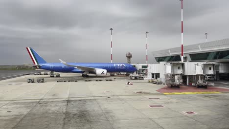 ita airways airplane at airport gate