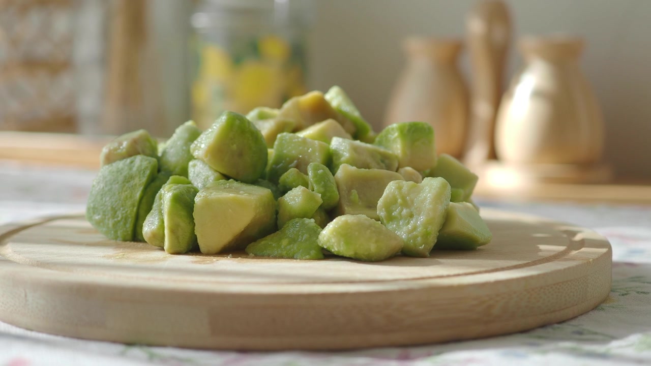 Pezzi di avocado fresco a cubetti su un tagliere di legno