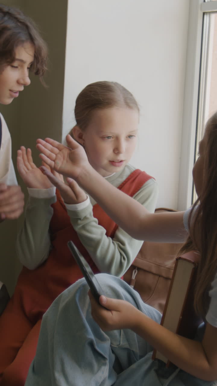 Young Students Discussing Content on a Tablet and Book