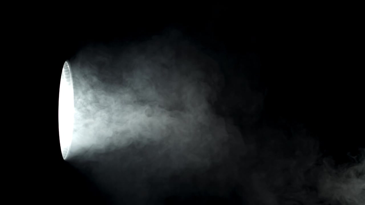 黒い背景に煙と霧が照らされた劇的なスポットライト