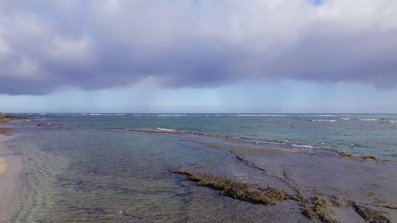 파도가 다이아몬드 헤드 (diamond head) 근처의 바위 연안에 부드럽게 굴러오르면서 태평양의 물결과 파도가 떠다니고 있습니다.