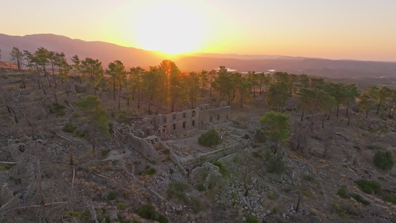 Veduta aerea delle rovine di un'antica città immerse tra gli alberi all'alba, Turchia