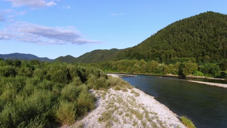 revelando abundante montaña de bosque verde cerca del lago, disparo de drones de baja altitud