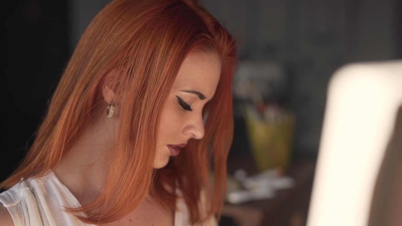 그녀의 작업실에 서서 그림을 그리는 매혹적인 젊은 빨간 머리 소녀의 클로즈업 초상화