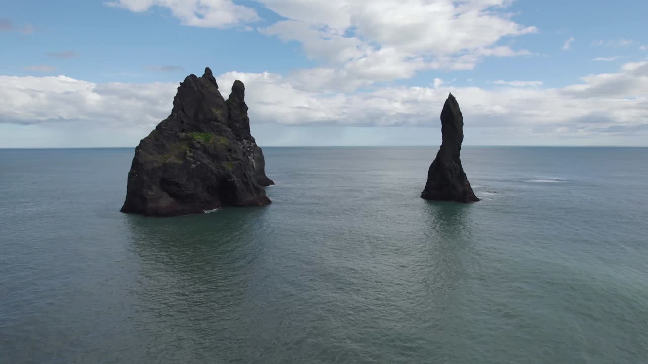tomada cinematográfica aérea volando hacia los pilares de reynisdrangar en islandia