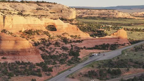 Sunlit-rock-formations-and-winding-road-in-the-desert-landscape-near-Moab,-Utah-USA