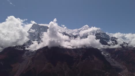 nubes corriendo en el cielo azul sobre el asombroso paisaje blanco de altas montañas rocosas y el valle nevado circuito de annapurna de himalaya nepal