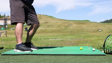 hombre practicando el swing de golf en el campo de manejo