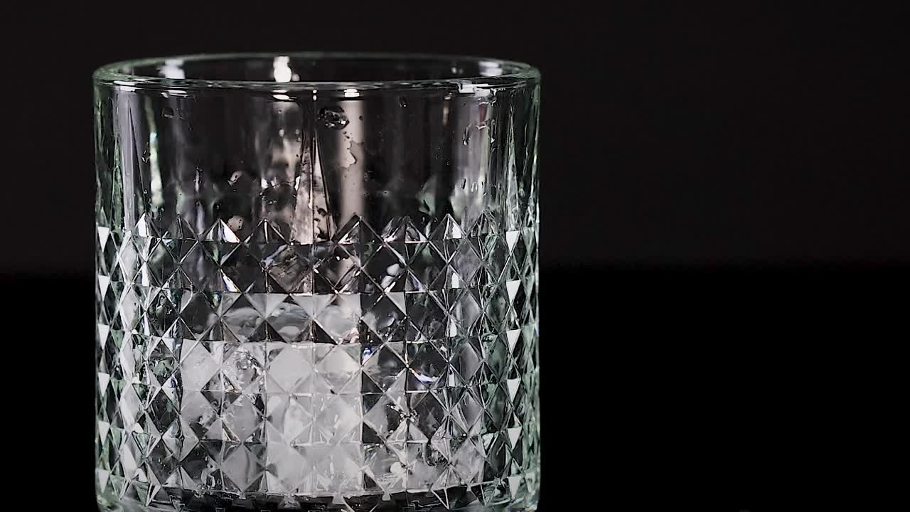 una rebanada de cal cae en un vaso con hielo