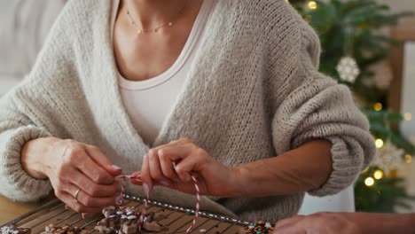 tilt up video of multi ethnicity couple packing gingerbread cookies as small christmas gifts.