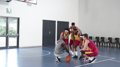 basketball team huddling with coach on court, preparing for game strategy