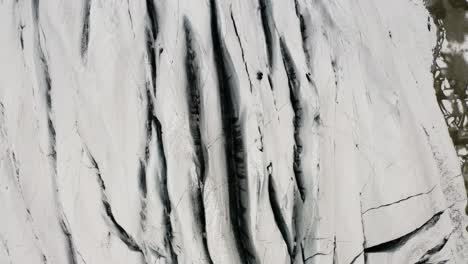 drone view tilt-up reveal of majestic snow-covered svinafellsjokull glacier in iceland