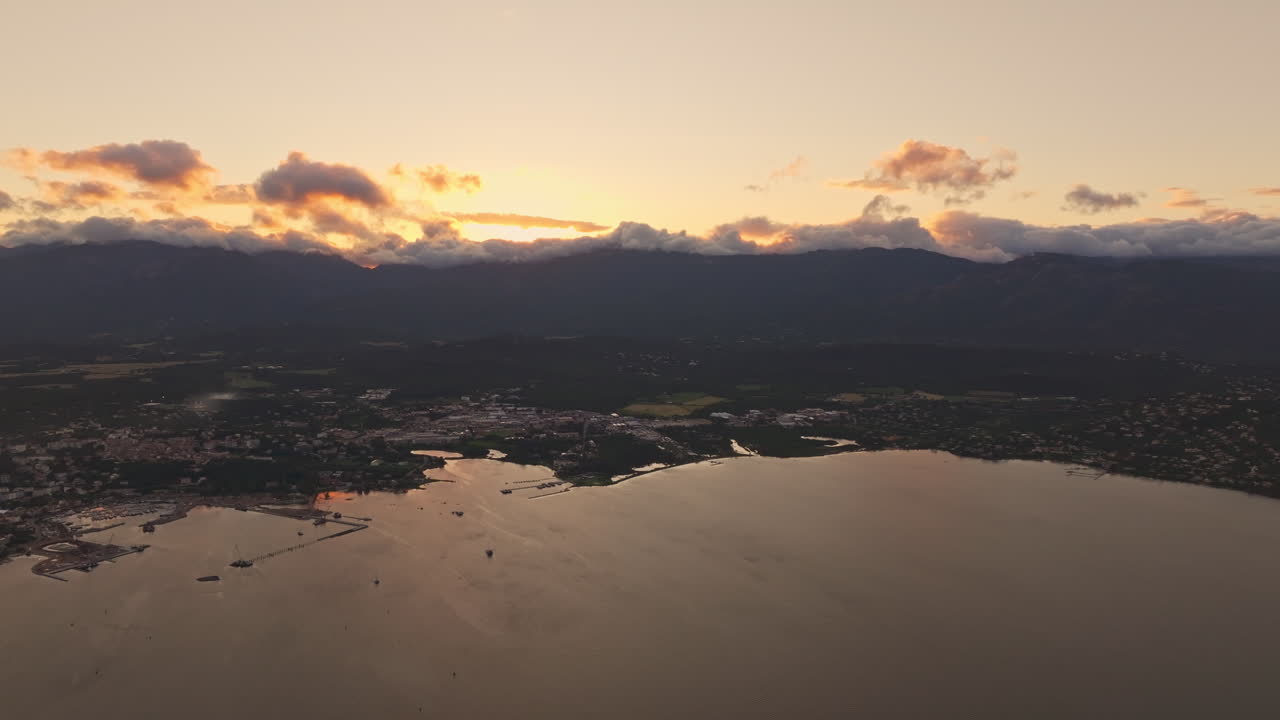Aerial drone shot over the coastline of Porto Vecchio, southern Corsica, France. Golden hour sunset, warm colorful sky