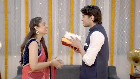 indian woman giving gifts to her husband on diwali
