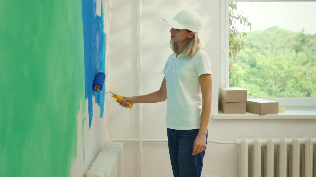 Woman painting a wall in a room