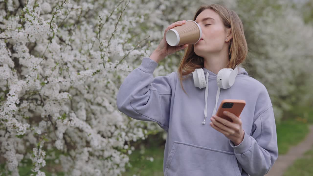 Donna che si gode un caffè in un parco primaverile