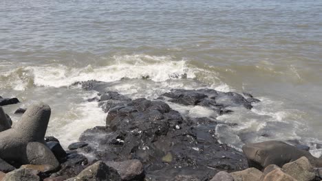 close up of waves breaking on bandra fort in mumbai india