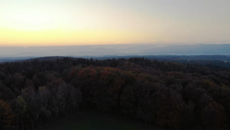 Clip-Aéreo-De-Los-Alpes-Bávaros-Durante-El-Amanecer,-Sobre-Un-Bosque