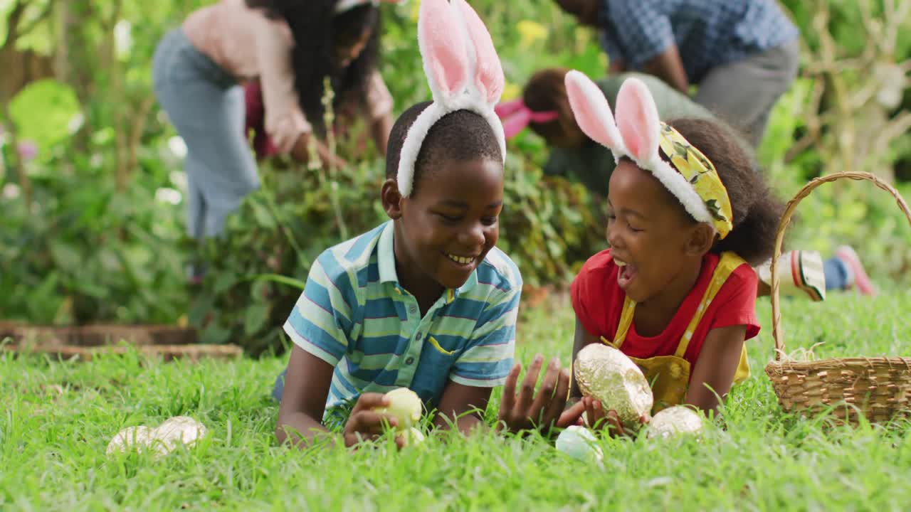 イースターエッグと一緒に芝生に寝そべっている、楽しそうなアフリカ系アメリカ人の兄弟姉妹のアニメーション