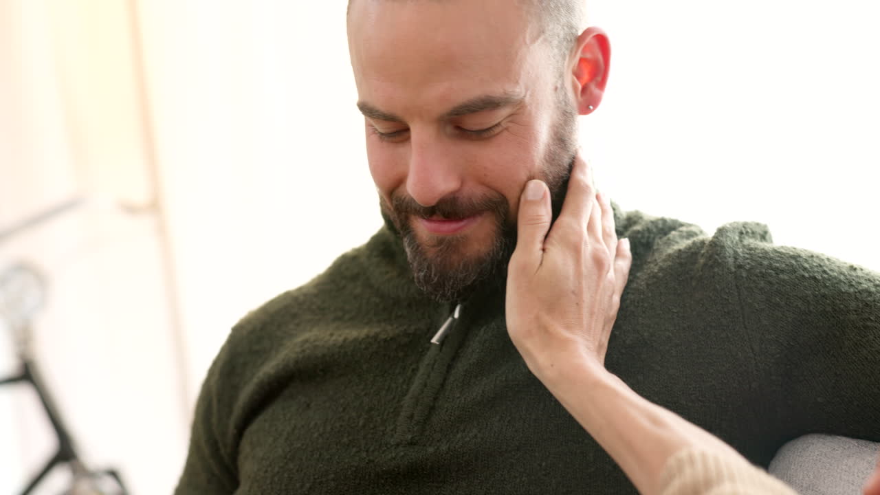 pareja tomados de la mano, besándose en el sofá