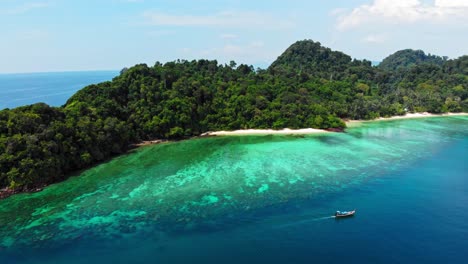 a beautiful island paradise in thailand with a boat just outside the visible coral reef territory