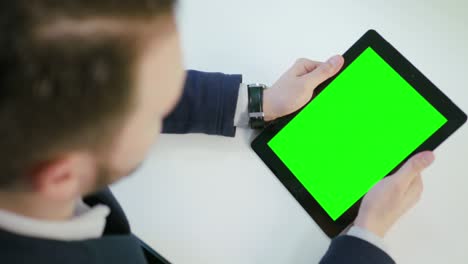 un hombre usando una tableta digital con una pantalla verde