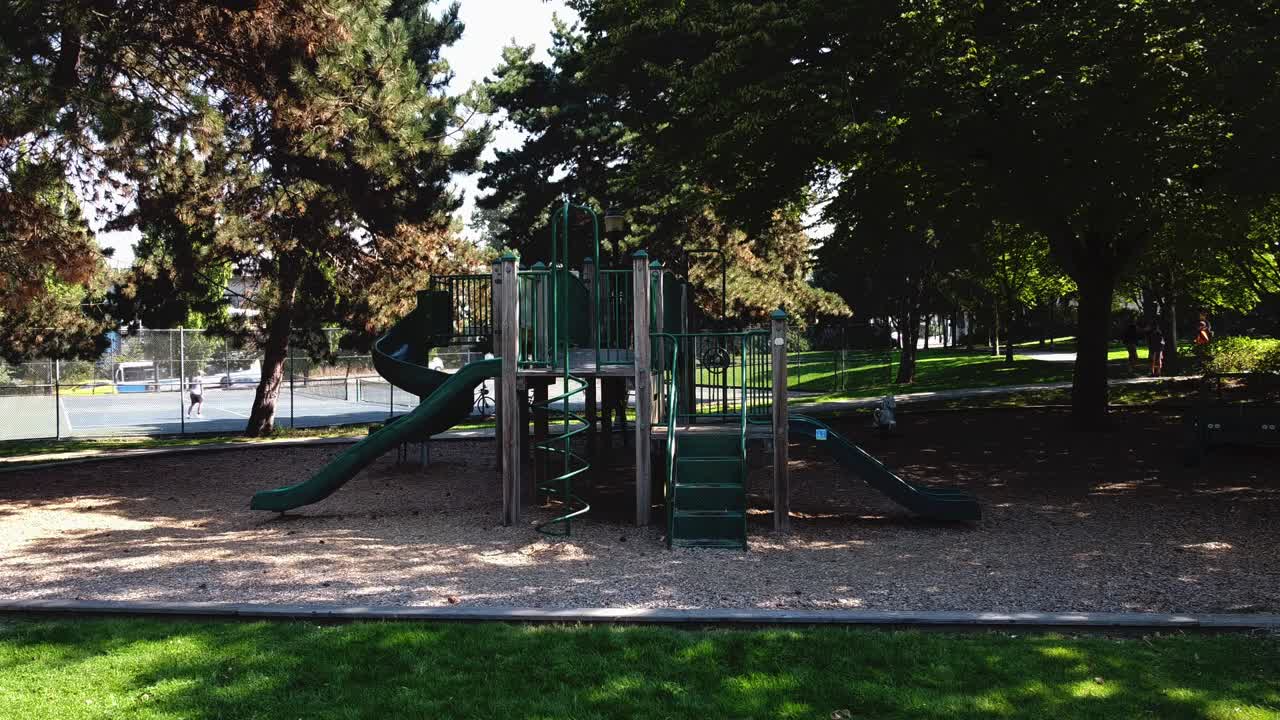 parque vacío durante la pandemia de covid-19 con restricciones publicadas en todo el patio de recreo verde vintage para limitaciones de distanciamiento social de seis pies junto a la cancha de tenis donde los adultos juegan la pelota