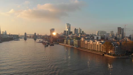 un dron deslizante disparó sobre el río támesis de londres hacia el centro de la ciudad sobre la puesta de sol de un edificio residencial