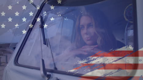 animation of american flag drawn over caucasian woman looking out of car window on beach