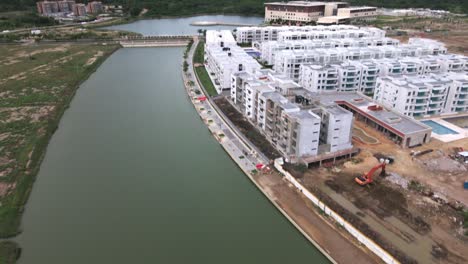 Aerial-View-of-Drone-Hovering-Above-River,-Adjacent-to-Construction-Buildings-in-Barranquilla