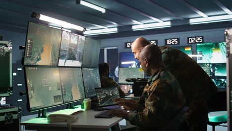 equipo de especialistas del ejército examinando datos en la sala de monitoreo