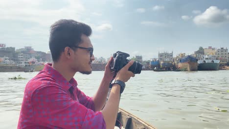 young male freelance photographer photographing from boat