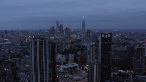 Imágenes-Aéreas-Nocturnas-Del-Paisaje-Urbano.-Altos-Edificios-Residenciales-En-El-Barrio-De-Elefantes-Y-Castillos.-Grupo-De-Rascacielos-En-El-Centro-Financiero-De-La-Ciudad-En-Segundo-Plano.-Londres,-Reino-Unido