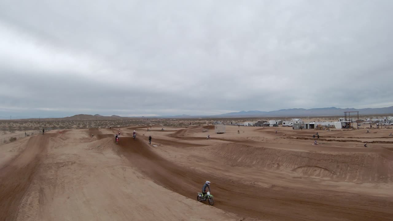 모하비 사막의 경마장 주위를 날아다니며 높은 점프를 하는 오토바이 - 최고의 공중 전망
