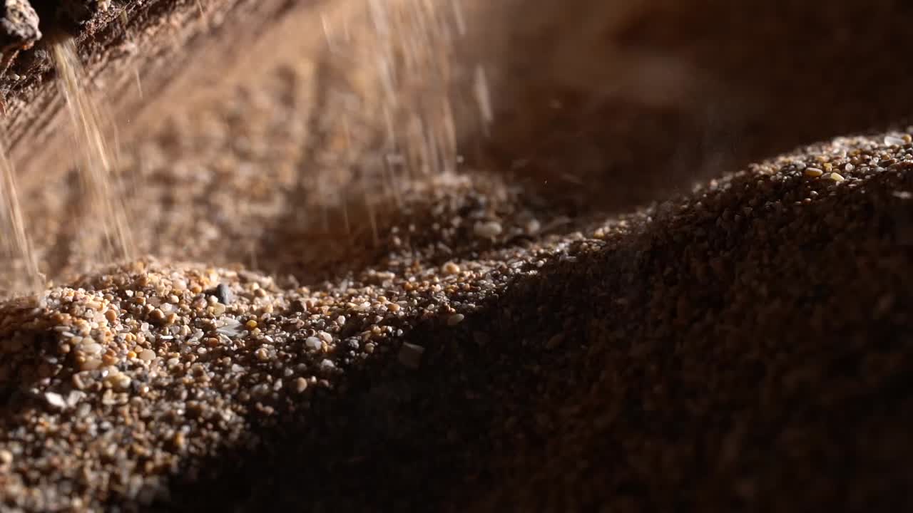 Close Up Of A Industrial Machine Dropping Sand Used For Landscaping, Natural Material.