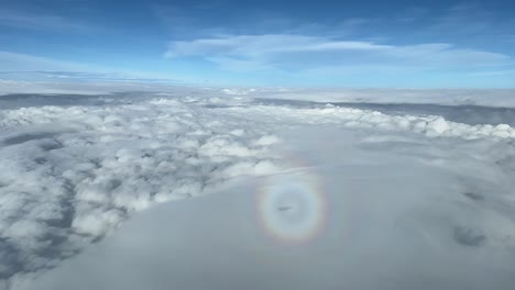 stunning view of the halo of a jet plane, side window wiew of the cockpit, while overflying some layers of stratus at 10000 m