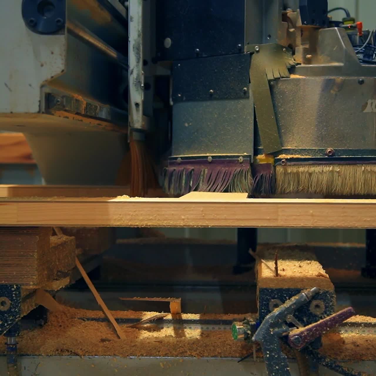 Massive automatic machine moves along the door billet. Automated equipment at door producing factory