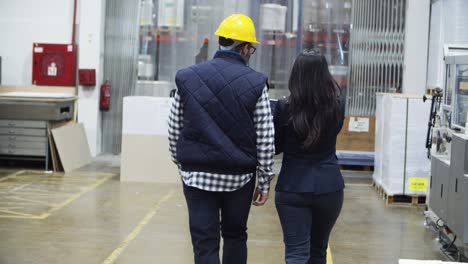 Back-view-of-project-manager-and-engineer-walking-at-factory