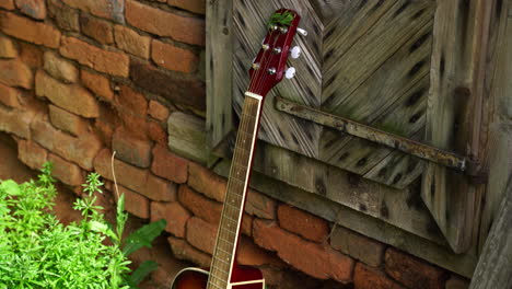 una guitarra en un antiguo establo cerca de un pueblo