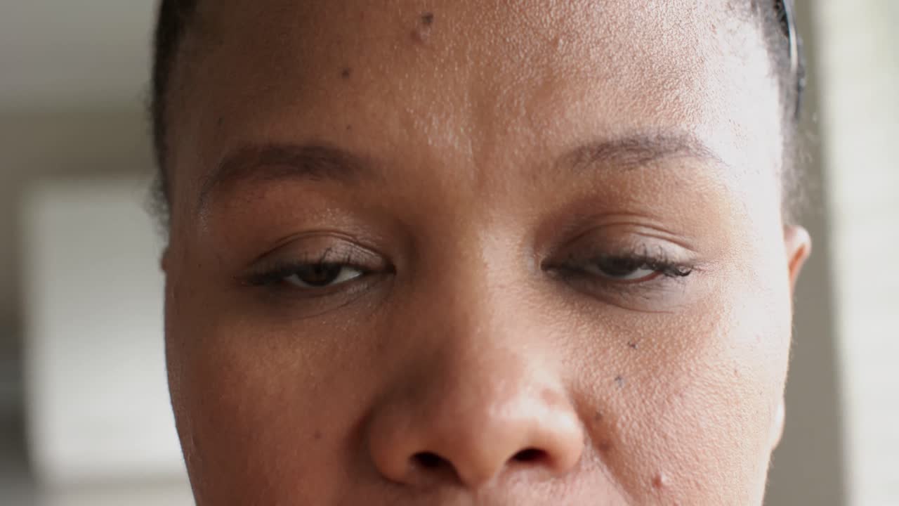 Portrait of happy african american woman looking at camera and smiling, in slow motion